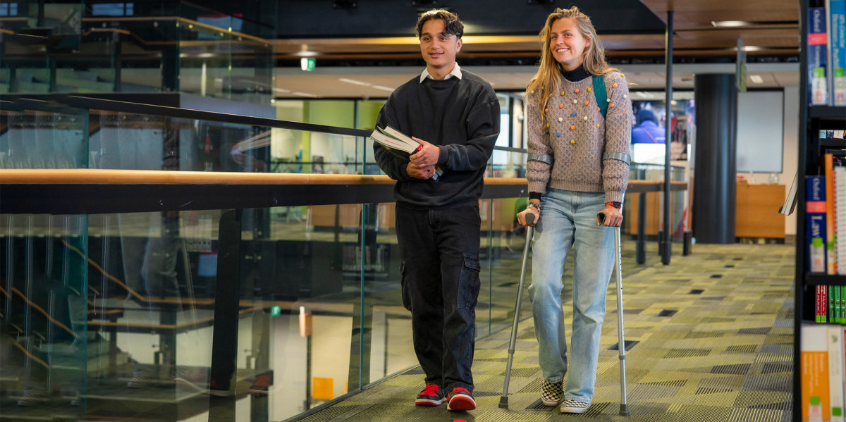 Two learners walking in a library