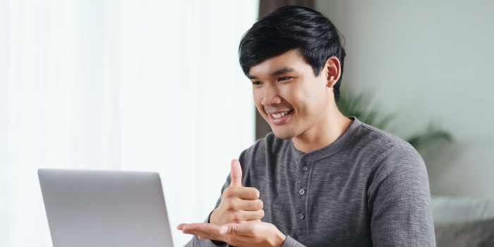 Person at laptop communicating with sign language