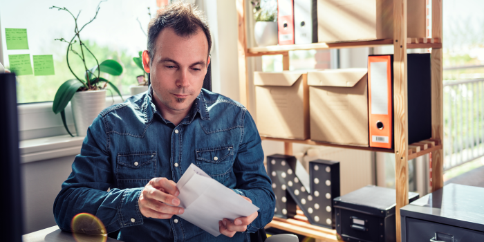 Person in office putting a letter in envelope