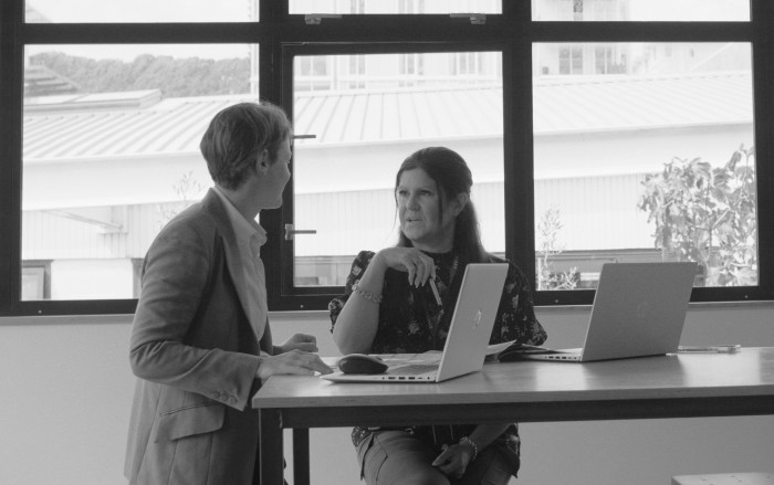 Two people talking in front of bright window